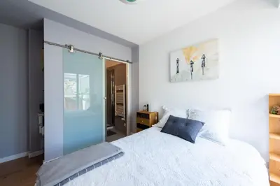 a bedroom with a white bed with a blue pillow at Happyfew la terrasse de Selfina in Nice