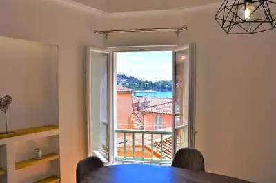 a dining room with a table and a large window at LARA AP4441 By Riviera Holiday Homes in Villefranche-sur-Mer