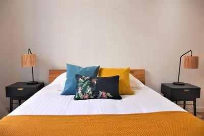 a bed with yellow and blue pillows on it at LARA AP4441 By Riviera Holiday Homes in Villefranche-sur-Mer
