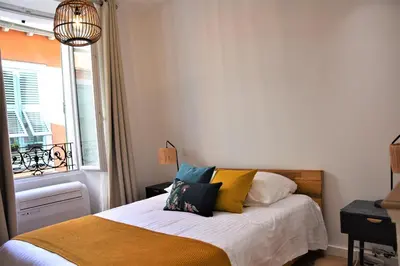 a bedroom with a bed with colorful pillows on it at LARA AP4441 By Riviera Holiday Homes in Villefranche-sur-Mer