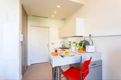 a kitchen with a counter and a red chair at Studio hyper-centre de Nice in Nice