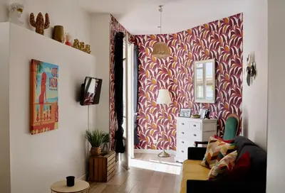 a living room with a couch and a red and white wallpaper at Studio with Big terrace full center with air conditioning in Nice