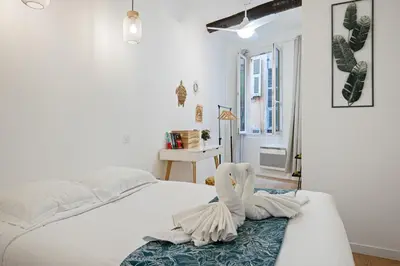 a bedroom with a white bed with a towel on it at Le Castelosa - Au coeur du Vieux-Nice in Nice