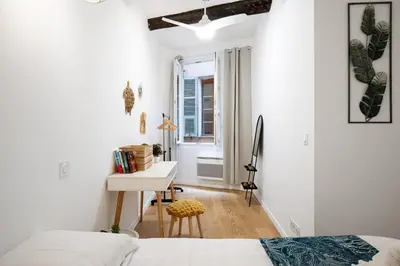 a white bedroom with a desk and a bed at Le Castelosa - Au coeur du Vieux-Nice in Nice
