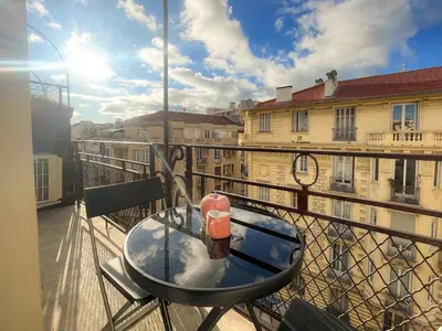 a table on a balcony with a view of a building at Nice Gare Studio in Nice