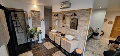 a bathroom with two sinks and a stone wall at Chambres d'hôtes D'AQUI D'AIA in Saint-Laurent-du-Var
