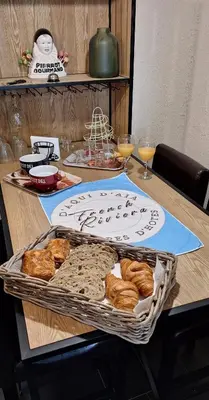 a table with a tray of bread and glasses of wine at Chambres d'hôtes D'AQUI D'AIA in Saint-Laurent-du-Var