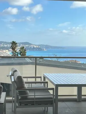 a table and chairs on a balcony with a view of the ocean at Appartement d'exception vue mer Nice Blue Pearl in Nice