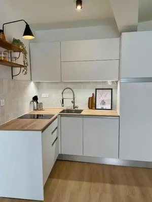 a kitchen with white cabinets and a sink and a refrigerator at Cosy 1 Bedroom Place Massena in Nice