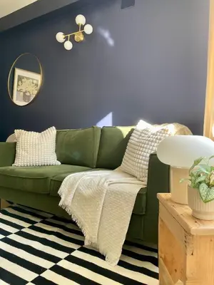 a green couch in a living room with a blue wall at Cosy 1 Bedroom Place Massena in Nice