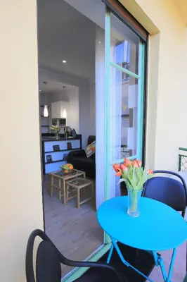 a blue table and chairs in a living room at La Suite Liberation in Nice