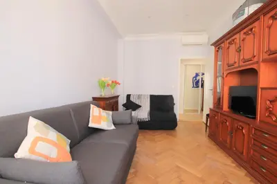 a living room with a couch and a television at La Suite Liberation in Nice