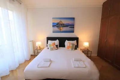 a bedroom with a large white bed with two pillows at La Suite Liberation in Nice