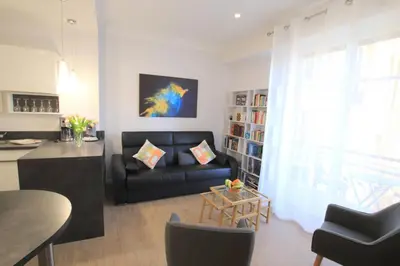 a living room with a black couch and a book shelf at La Suite Liberation in Nice