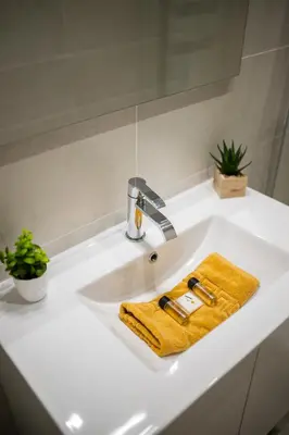 a bathroom sink with a yellow towel and a faucet at Maison de ville familiale, 5 chambres, terrasse, à 20 minutes du centre ville in Nice