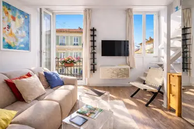 a living room with a couch and a tv at French Riviera Escapade - Steps from the Beach in Nice