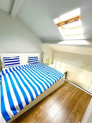 a bedroom with a bed with blue and white stripes at French Riviera Escapade - Steps from the Beach in Nice