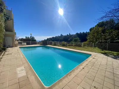 a large blue swimming pool in a yard at Nice Ouest 2P Sea view, Pool, Quiet in Nice