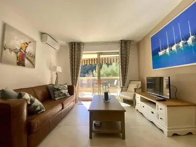 a living room with a couch and a tv at Nice Ouest 2P Sea view, Pool, Quiet in Nice