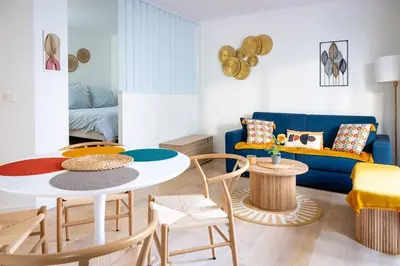 a living room with a table and a blue couch at Rivoli- Quiet apartment, close to Negresco in Nice