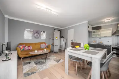 a living room and kitchen with a table and a couch at Cozy Appartement close to Port of Nice in Nice