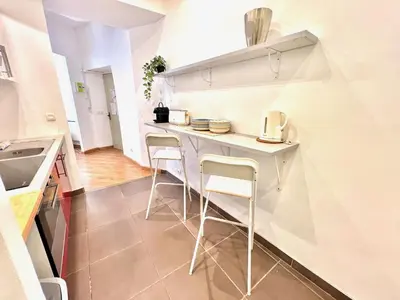 a small kitchen with a white counter and stools at ApartHotel Riviera - La Maison De Francois - Old Town in Nice