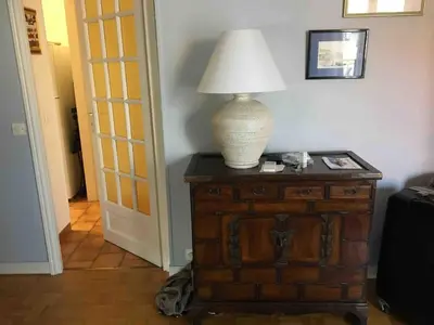 a lamp sitting on top of a wooden table at Pleasant central apartment with balcony in Nice