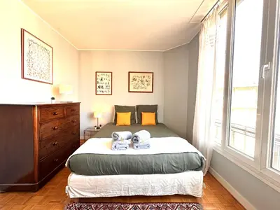 a bedroom with a bed and a large window at Pleasant central apartment with balcony in Nice