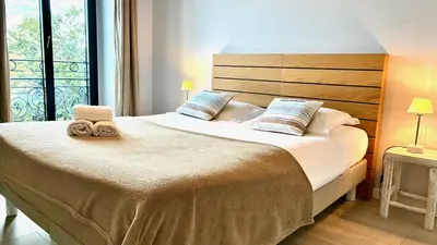 a bedroom with a large bed with two towels on it at ApartHotel Riviera - Terrasse Felix Faure 2 - Massena in Nice