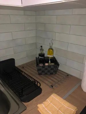 a kitchen counter with a stove with a bottle of alcohol at Lovely cozy studio in Nice