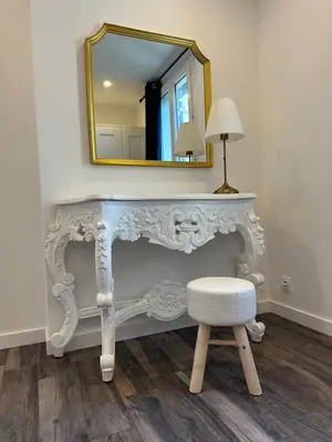 a dressing table with a stool and a mirror at Gîte Le Tilleul in Aspremont