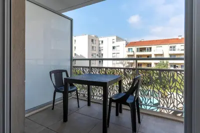 three chairs sitting next to a swimming pool at Quality Aparthotel Nice in Nice
