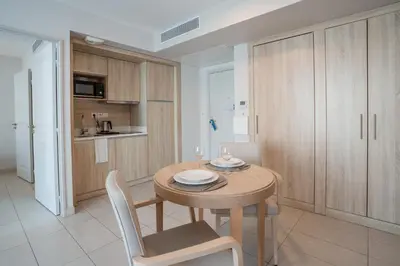 a kitchen and dining room with a table and chairs at Quality Aparthotel Nice in Nice