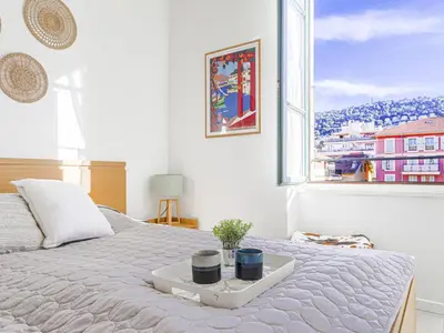 a bedroom with a white bed with a window at Apartment Le Palais du Vieux Port by Interhome in Nice
