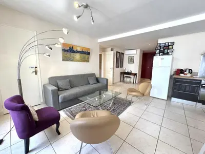 a living room with a couch and a table at ApartHotel Riviera - Hotel des Postes 2 - City center Massena in Nice
