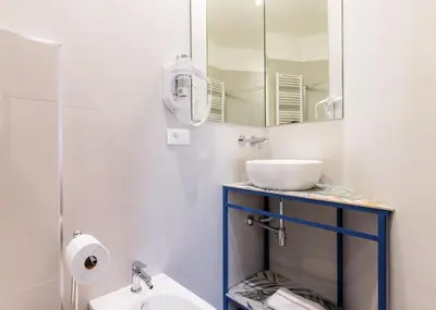 a white bathroom with a sink and a mirror at Azur BnB in Nice