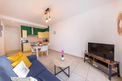 a living room with a blue couch and a kitchen at Joli cocon à 3 min à pied de la mer in Nice