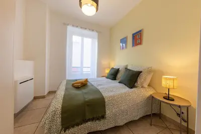 a bedroom with a bed and a table with a lamp at Joli cocon à 3 min à pied de la mer in Nice