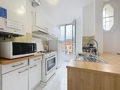 a white kitchen with a sink and a microwave at Nice Carlone Appart 6 pers, Clim, proche mer, transports in Nice