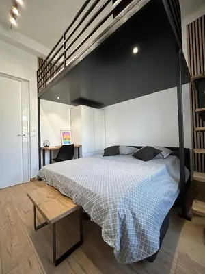 a bedroom with a large bed with a black canopy at Studio en plein cœur de Nice in Nice