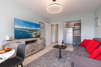 a living room with a couch and a large screen tv at MY CASA - MEDECIN 26 - Superb Apt Suite Downtown in Nice