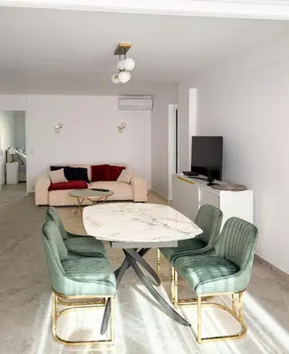 a living room with a table and chairs and a couch at Appartement de luxe climatisé, parking & 2 balcons in Villefranche-sur-Mer