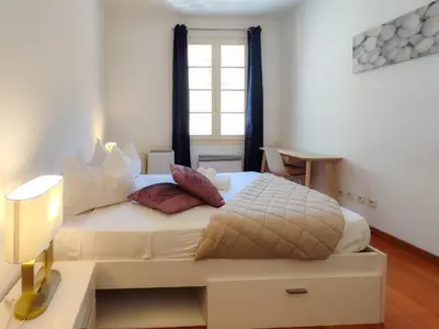 a bedroom with a large white bed with a window at Grimaldi Centrale 3 Pers WiFi AC in Nice