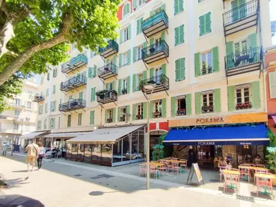 a street in front of a building with tables and chairs at Grimaldi Centrale 3 Pers WiFi AC in Nice