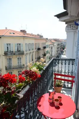 a red table and chairs on a balcony at Top floor appartement - central in Nice