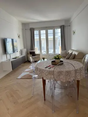 a living room with a table and chairs in a room at Beautiful 3 rooms, Carré d 'Or in Nice