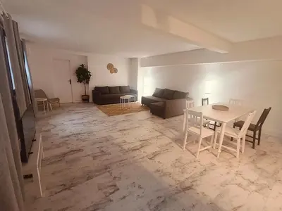 a living room with a table and a couch at Superbe appartement T2 de 95 m in Nice