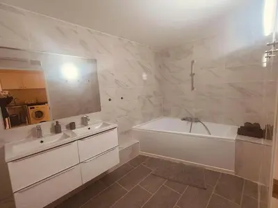 a white bathroom with a tub and a sink at Superbe appartement T2 de 95 m in Nice