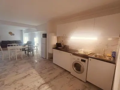 a kitchen with a washing machine and a kitchen with a table at Superbe appartement T2 de 95 m in Nice