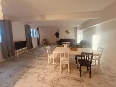 a living room with a white table and chairs at Superbe appartement T2 de 95 m in Nice